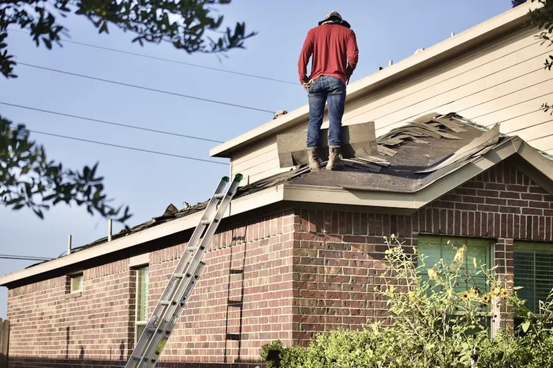 Professional roofer working on a residential roof in Point Comfort Woods